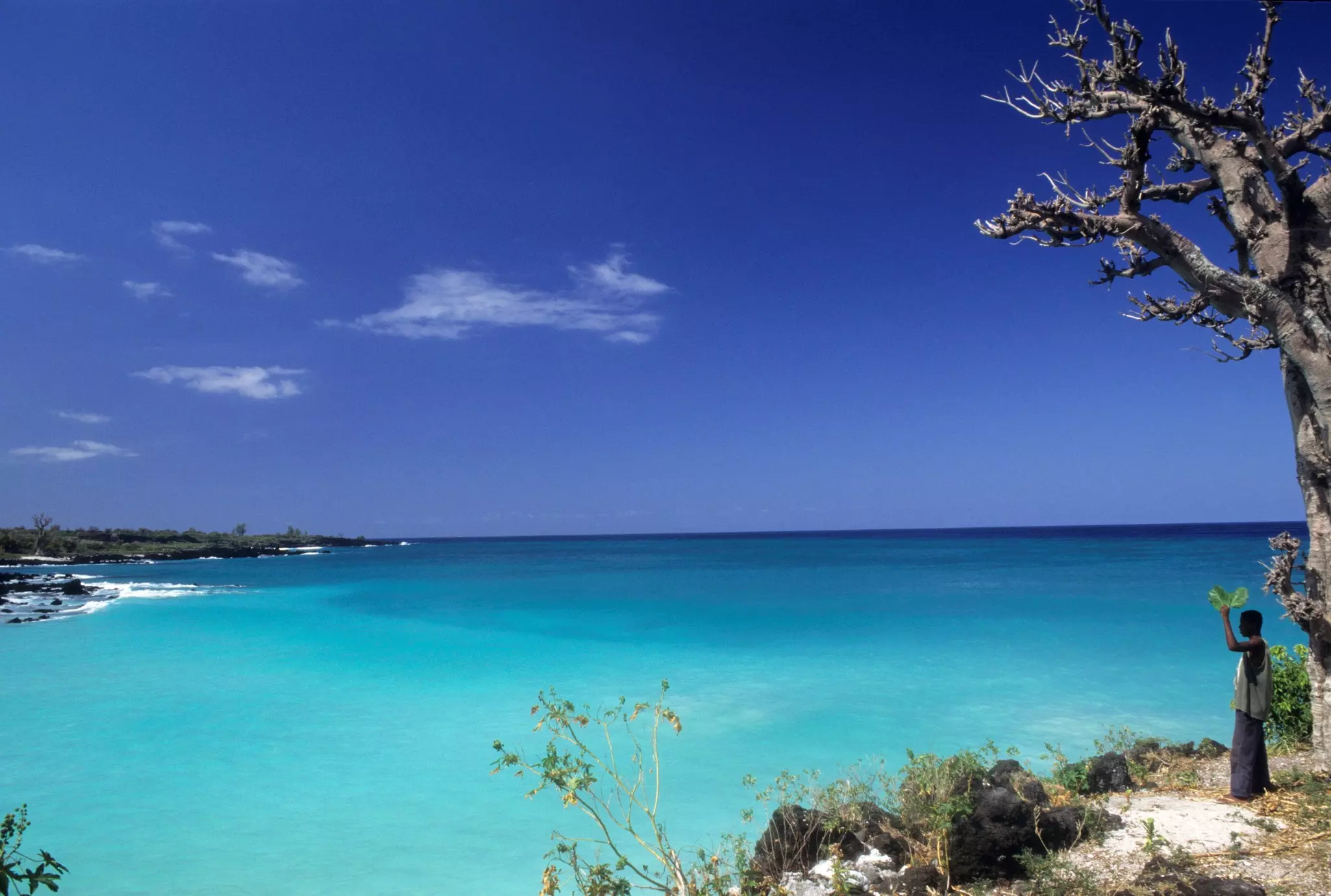 A man stanging on the edge of Le Galawa Beach, Grande Comore, Comoros, Africa