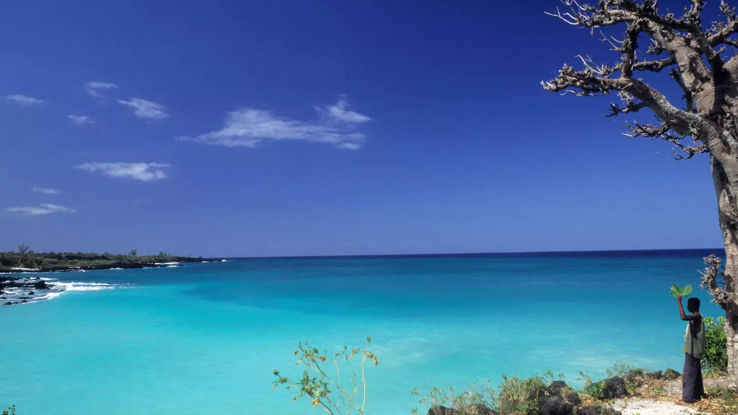 A man stanging on the edge of Le Galawa Beach, Grande Comore, Comoros, Africa