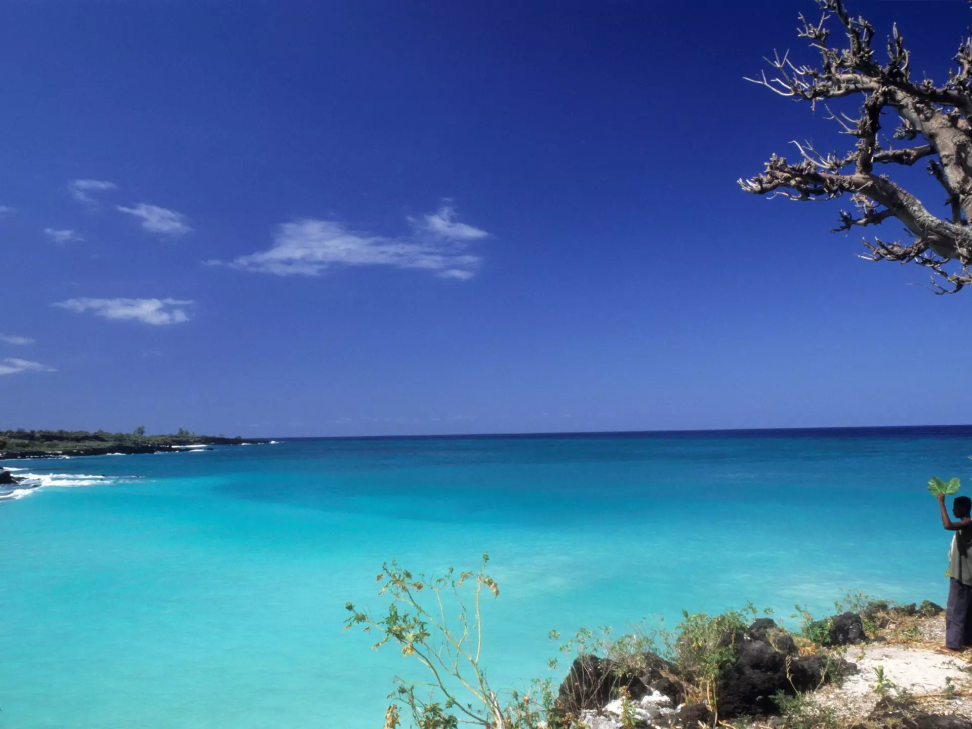 A man stanging on the edge of Le Galawa Beach, Grande Comore, Comoros, Africa
