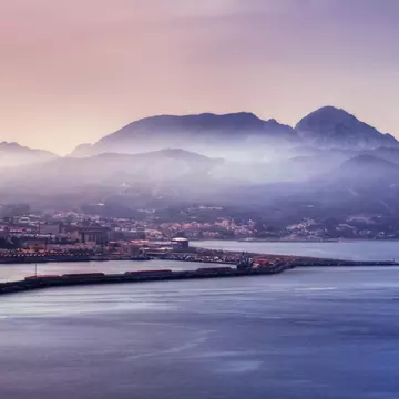 Aerial of the Ceuta harbour with a misty mountain range beyond.