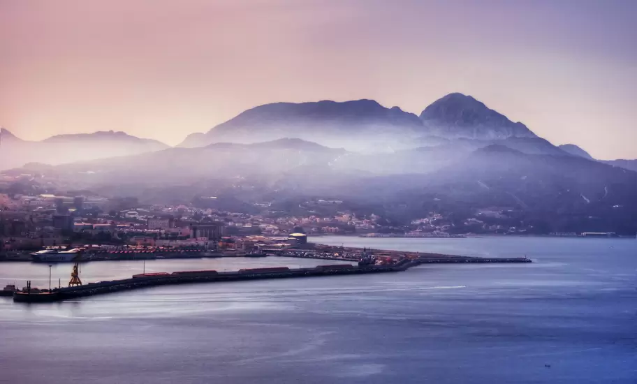Aerial of the Ceuta harbour with a misty mountain range beyond.