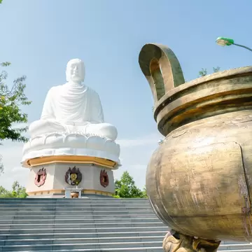 A view of a staircase with a large buddha statue at the top