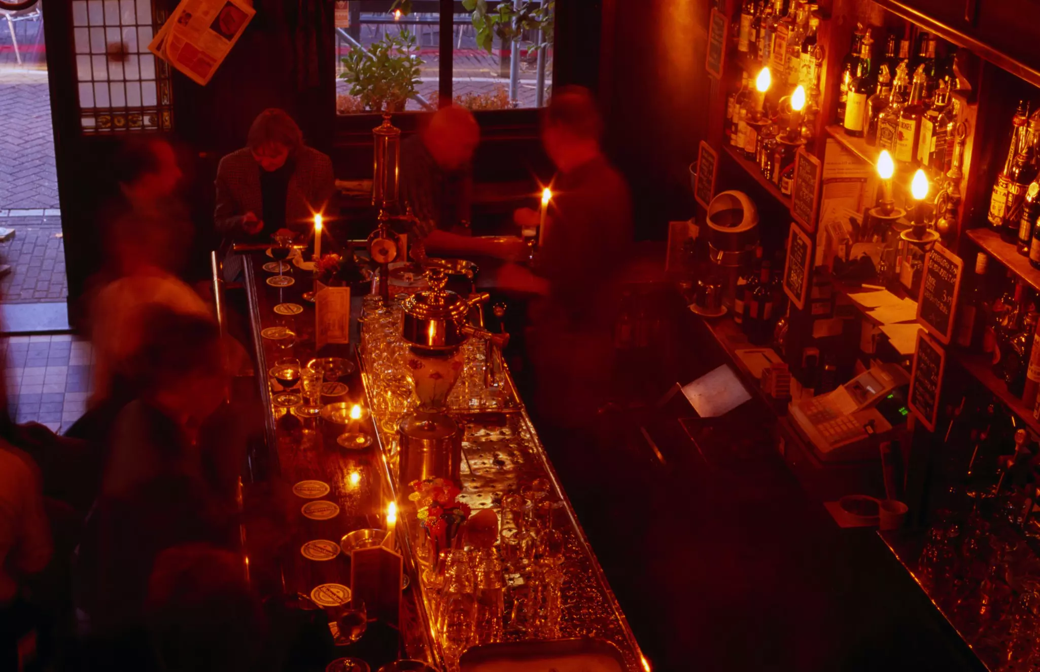 Looking down on the interior of a bar lit by warm light and candles.