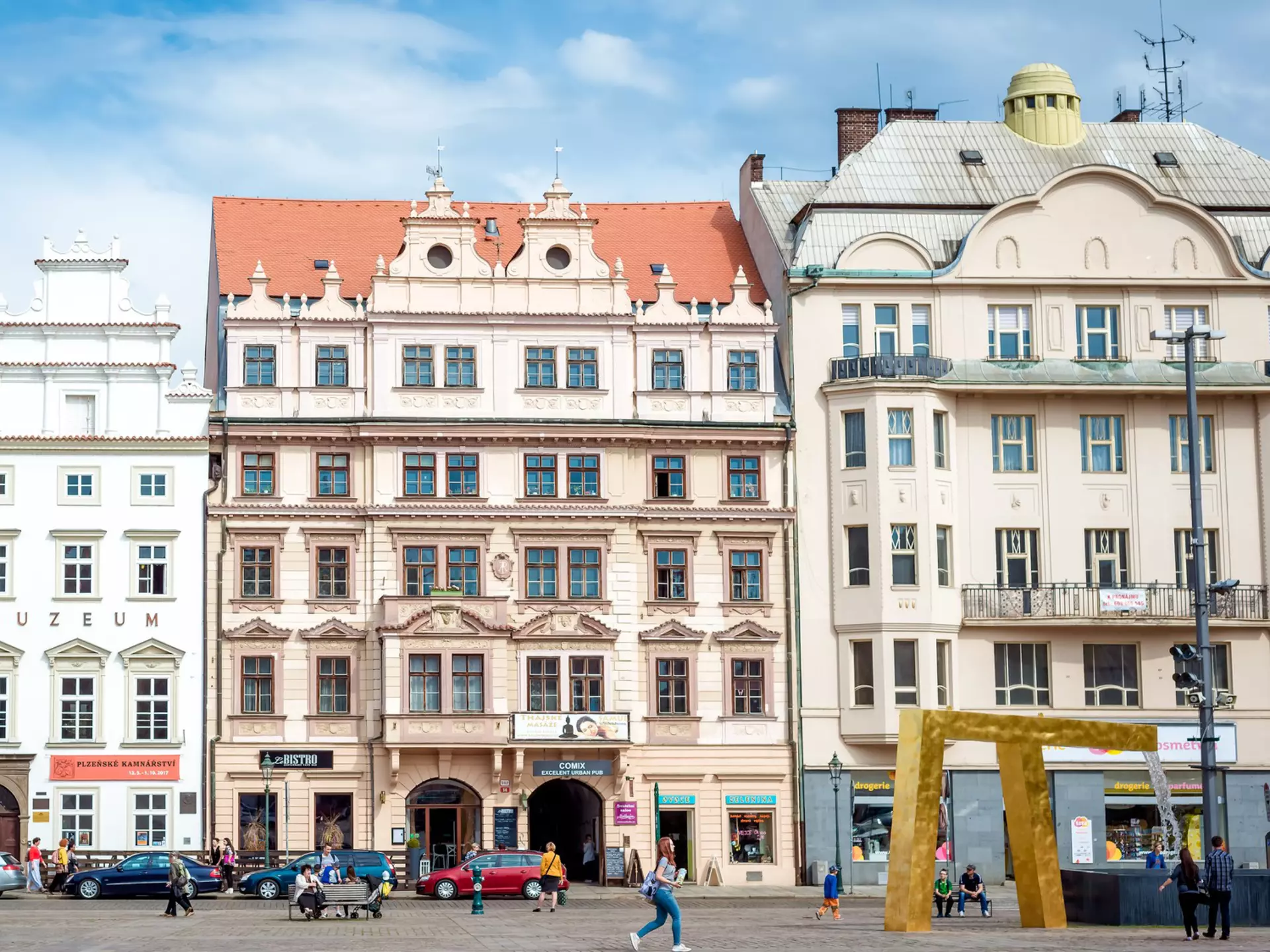 A row of pastel-colored baroque building facades in Plzeň, Czechia.
