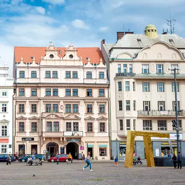 A row of pastel-colored baroque building facades in Plzeň, Czechia.