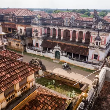 An aerial view of the roofs of historic mansions in a small village.