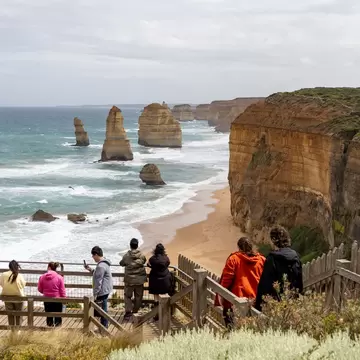 Visitors on a boardwalk overlook the Twelve Apostles limestone stacks and cliffs on the Great Ocean Road, Victoria