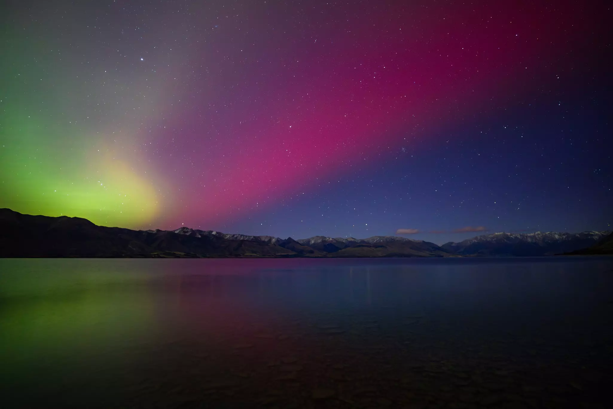 Colorful lights in the night sky over a lake.