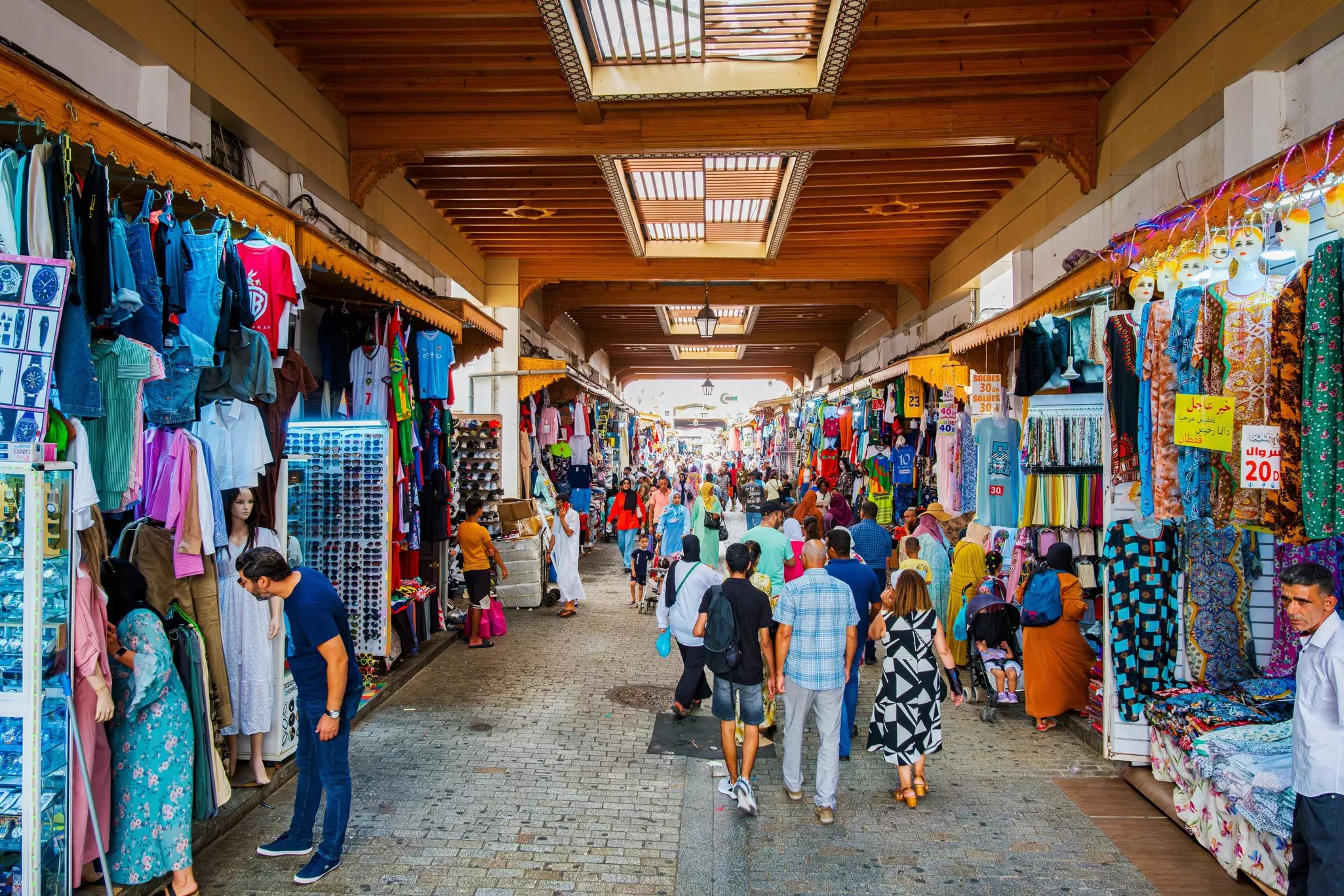 People shopping in a covered market selling clothes