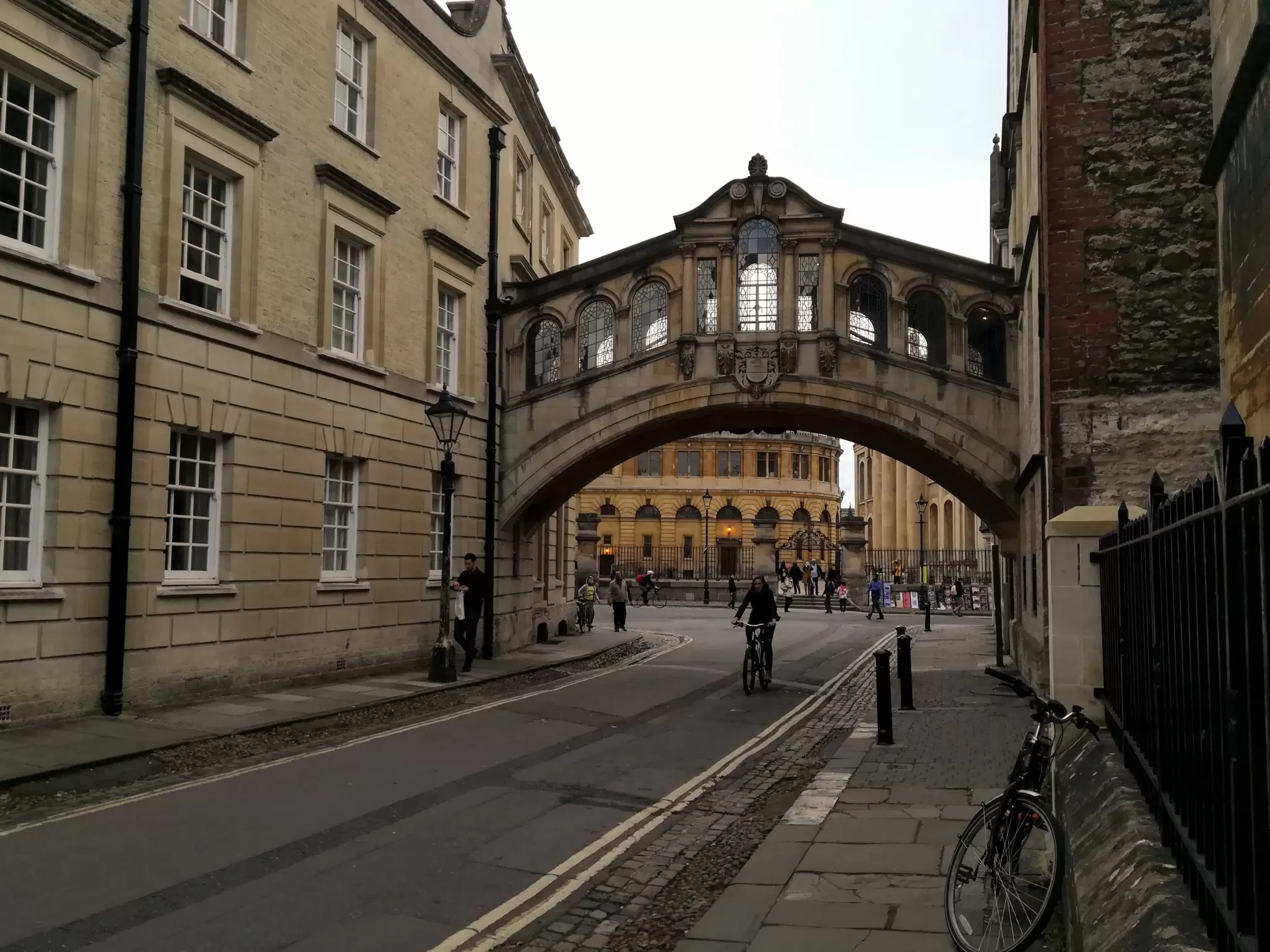 A man rides a bike under an enclosed bridge in Oxford, England. 
