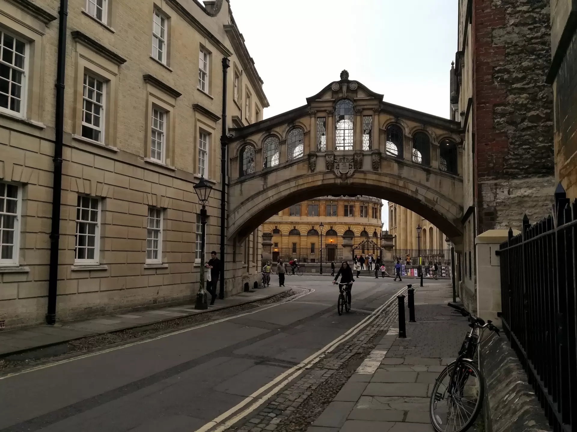 A man rides a bike under an enclosed bridge in Oxford, England. 