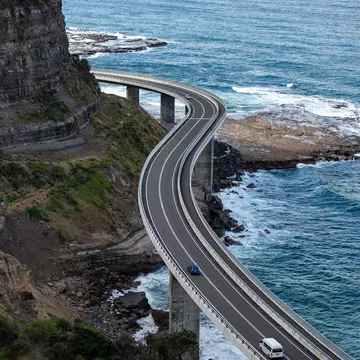 A windy highway causeway hugs cliffs above the ocean