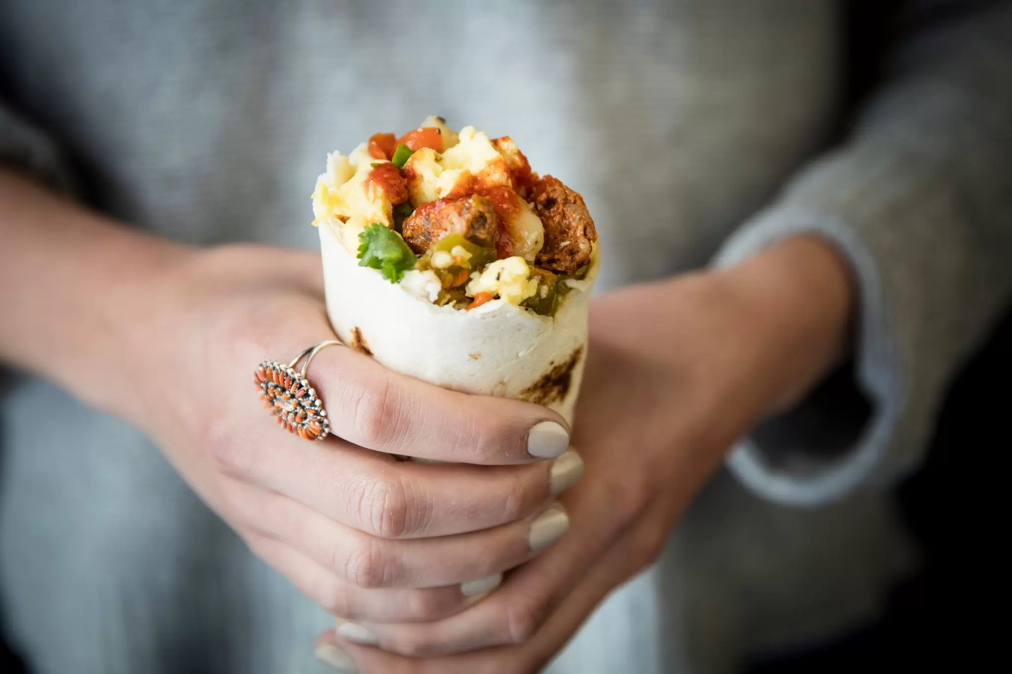 Person holding a breakfast burrito