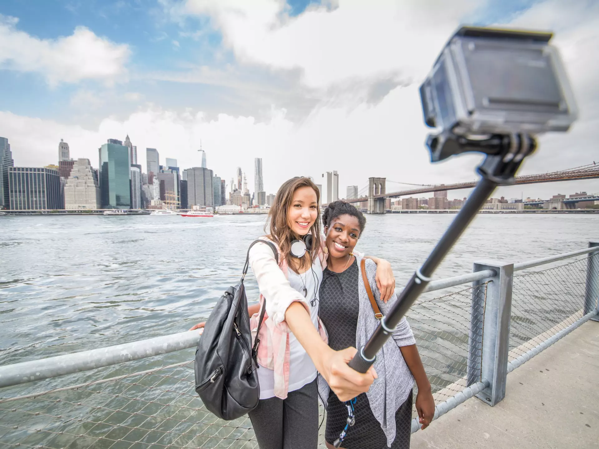 Two women taking a selfie with the New York skyline in the background
