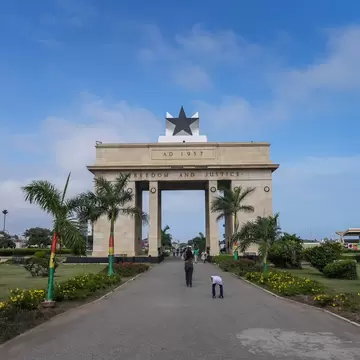 A large stone gateway with five-pointed black star on top. "AD 1957" and "Freedom and Justice" are inscribed in the stone.