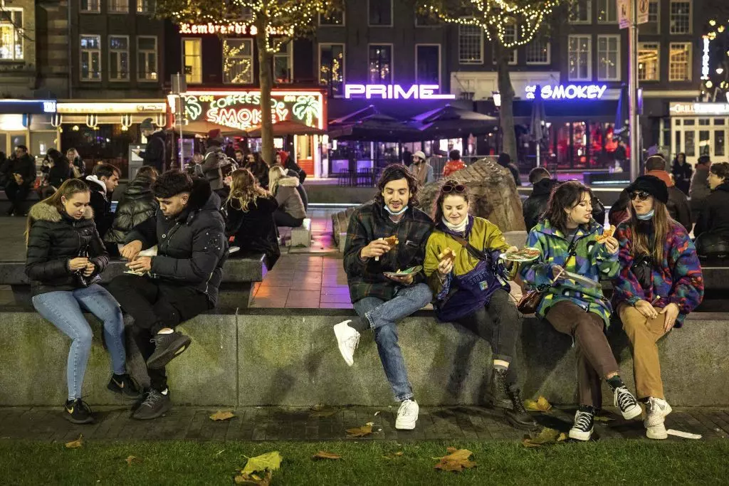 People line up outside a shop selling cookies on December 19, 2021 in Amsterdam ahead of the new Christmas lockdown
