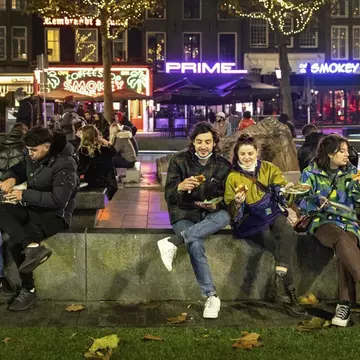People line up outside a shop selling cookies on December 19, 2021 in Amsterdam ahead of the new Christmas lockdown