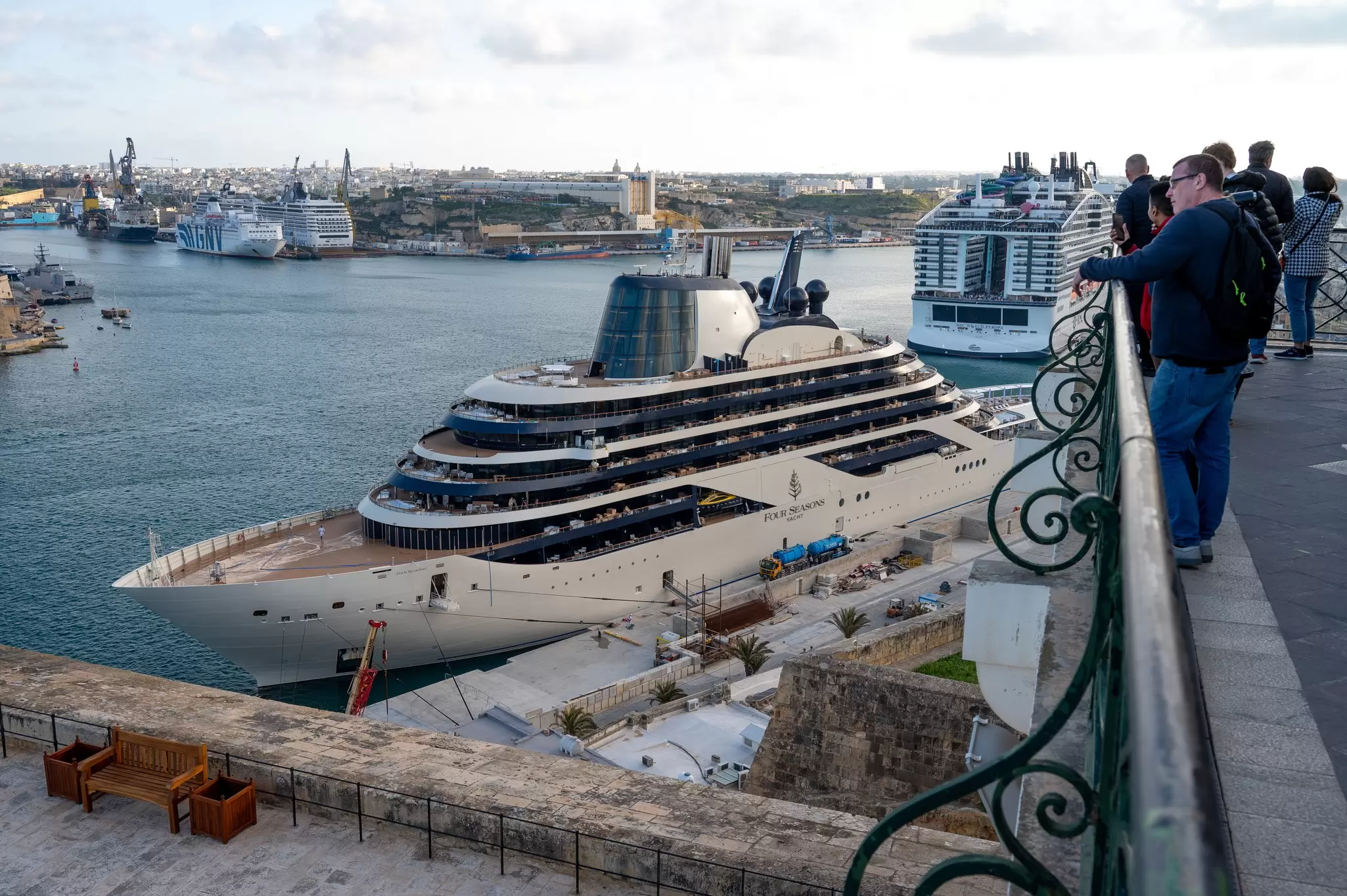 Looking down from a pier at luxury cruise ships docked at a city pier, Valletta, Malta