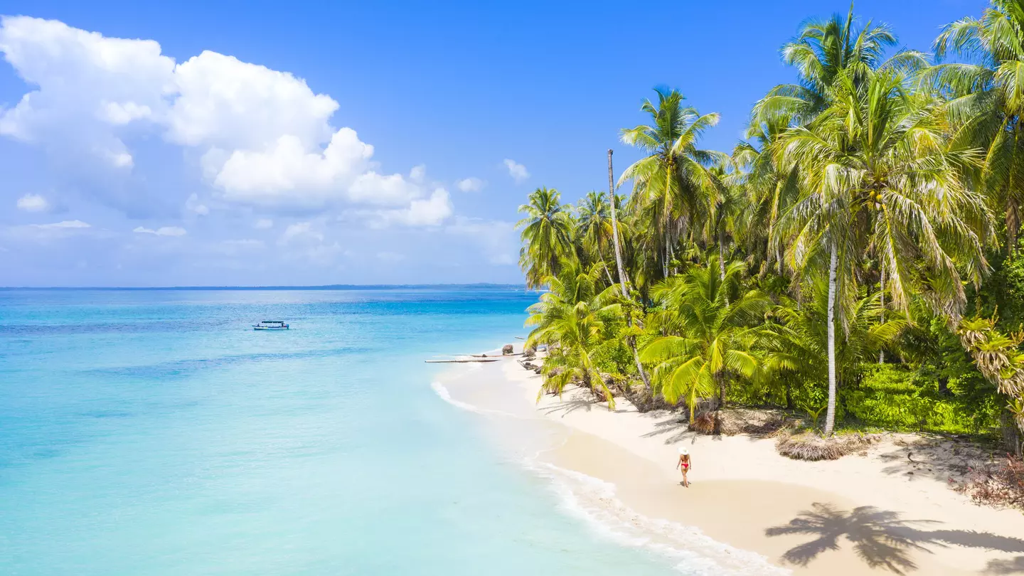 Woman walking on the beach in the Bocas del Toro islands. Zapatilla island, Panama