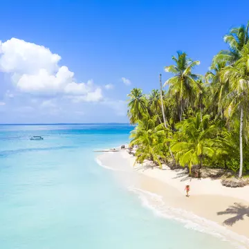 Woman walking on the beach in the Bocas del Toro islands. Zapatilla island, Panama