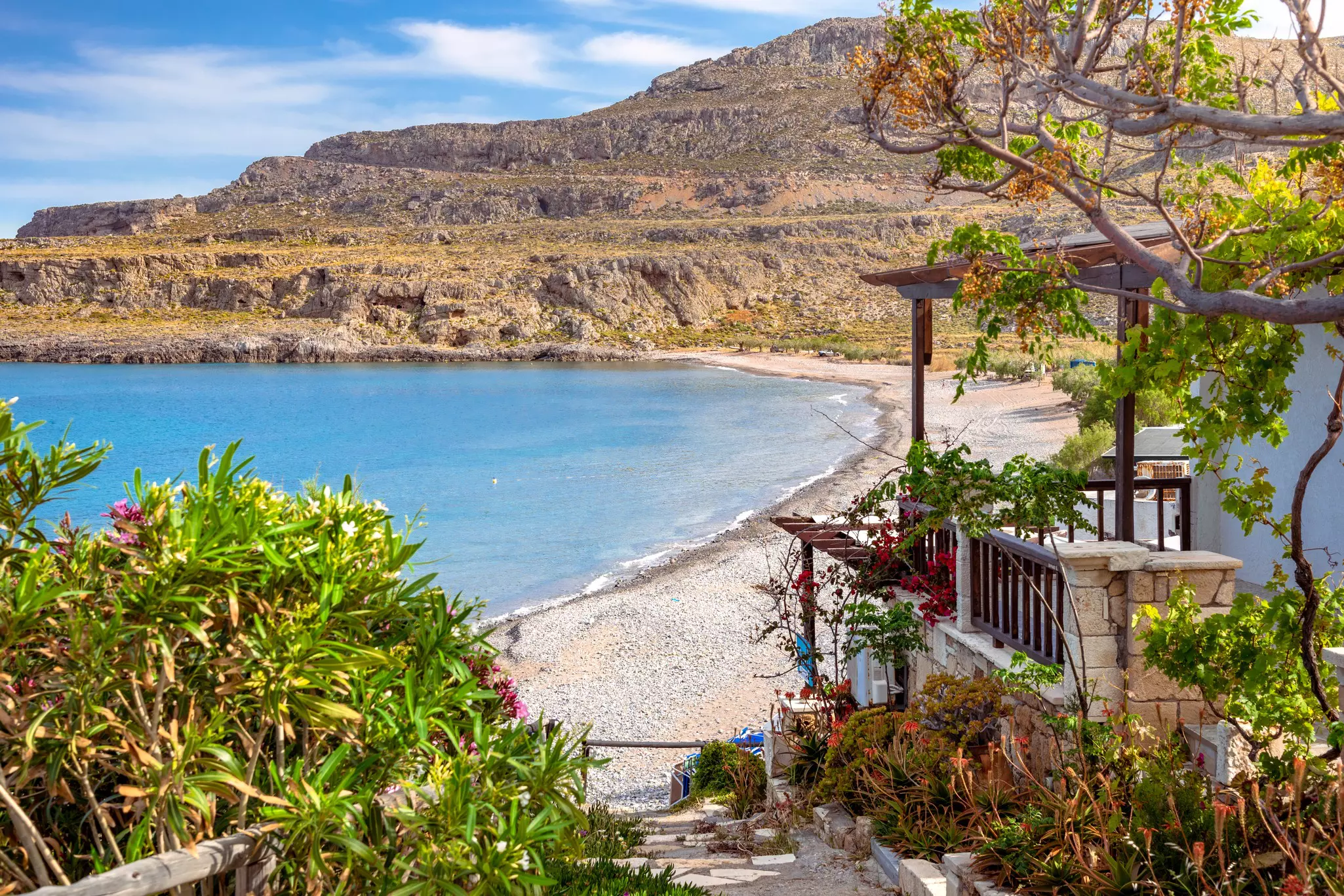 The peaceful village of Kato Zakros at the eastern part of the island of Crete with the beach visible between plants and houses. 