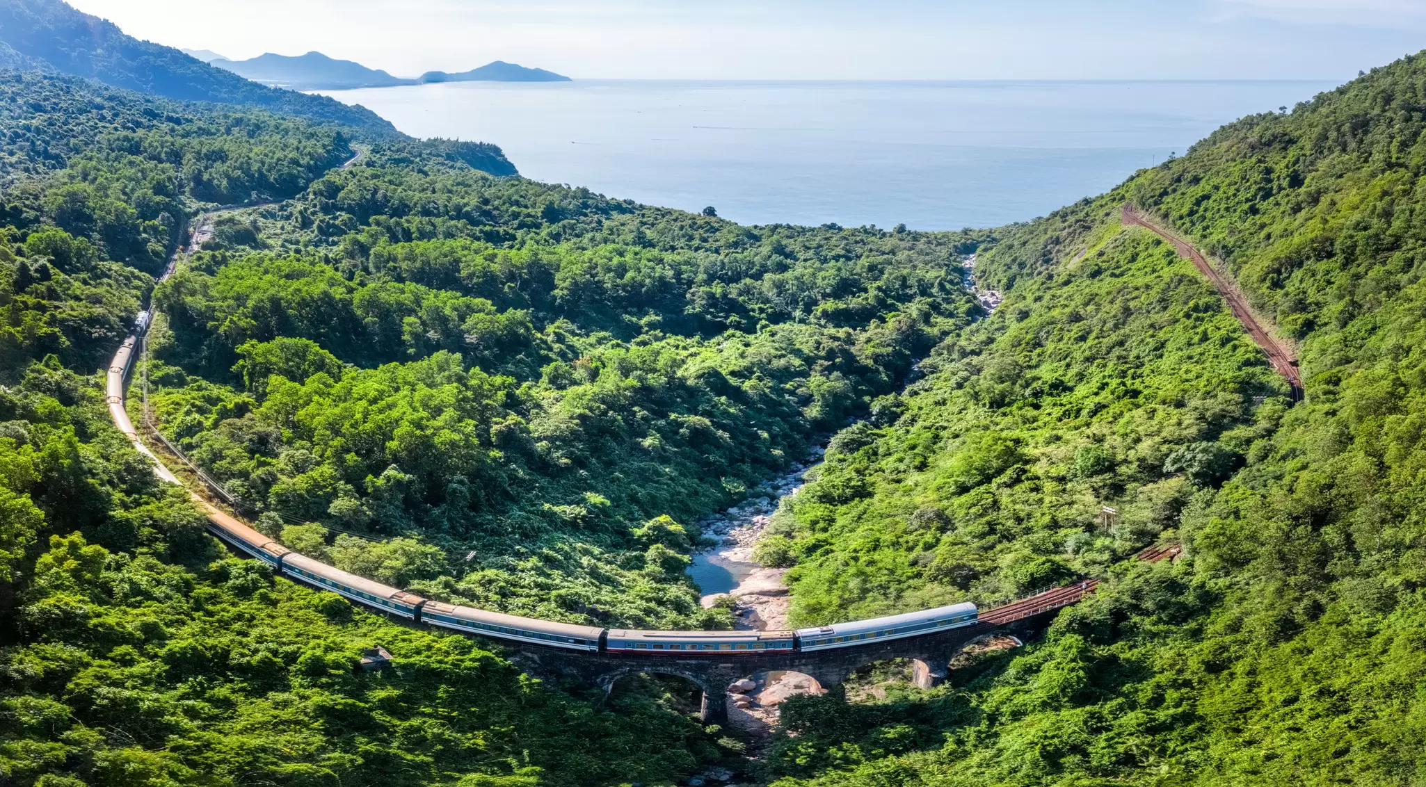 a train runs through the green countryside in Vietnam