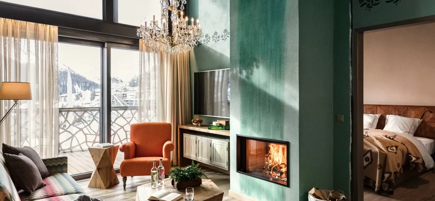 An apartment in a hotel with colorful furnishings and a fireplace: Valsana Hotel, Switzerland