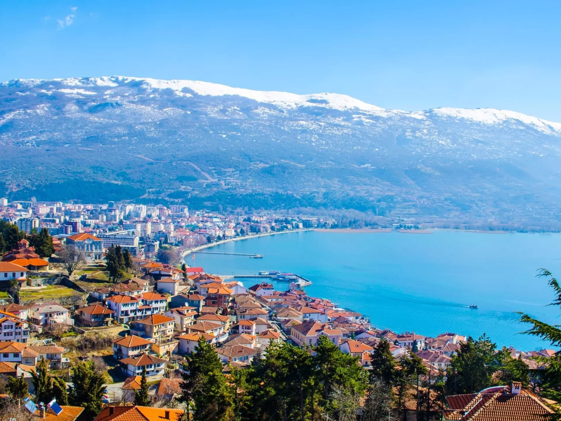 Snowy mountains rise above Lake Ohrid in North Macedonia.