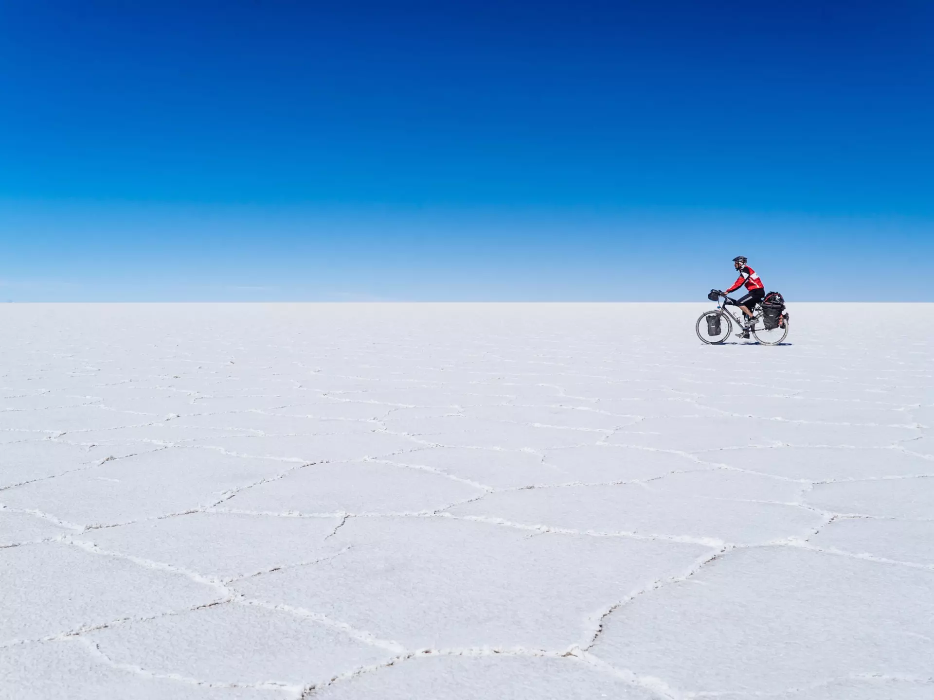 A long-distance cyclist passing through the Salar De Uyuni