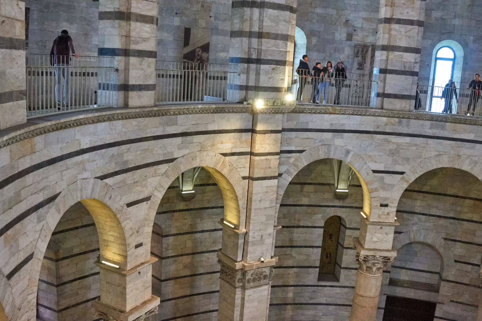 People inside the interior of the Pisa Baptistery of Battistero di San Giovanni.