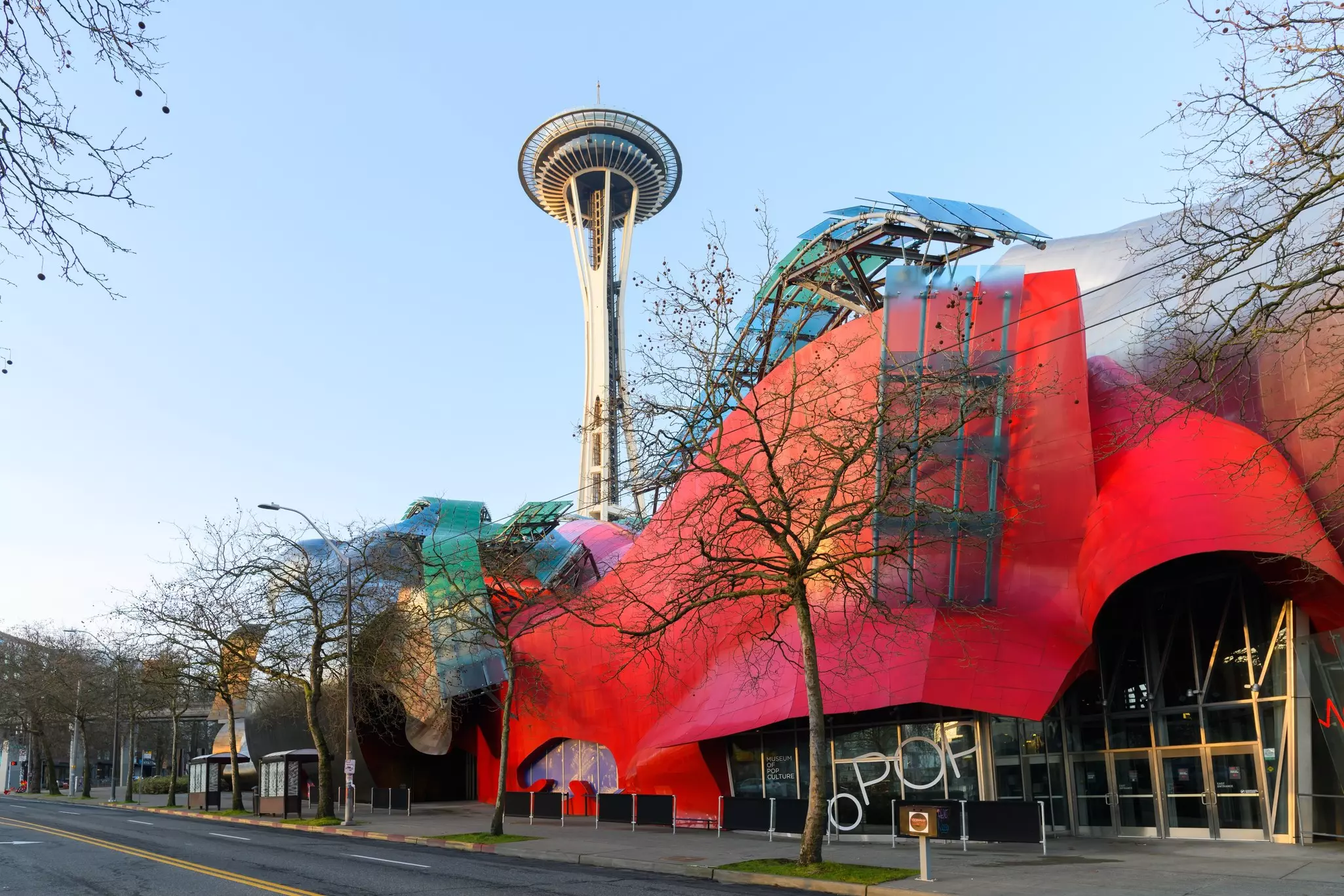 Modern building housing the Museum of Pop Culture or MoPOP in front of the Seattle Space Needle in morning light