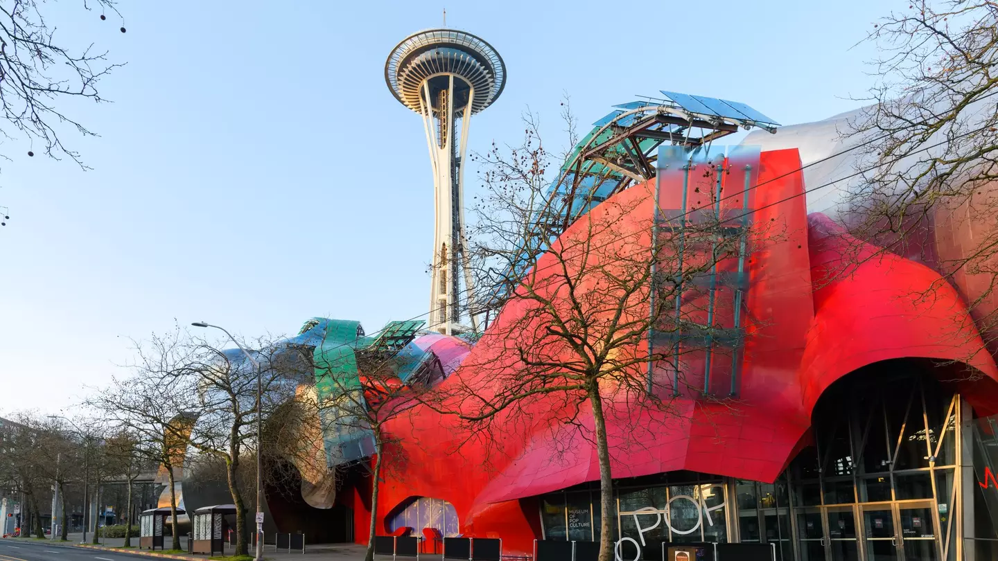 Modern building housing the Museum of Pop Culture or MoPOP in front of the Seattle Space Needle in morning light