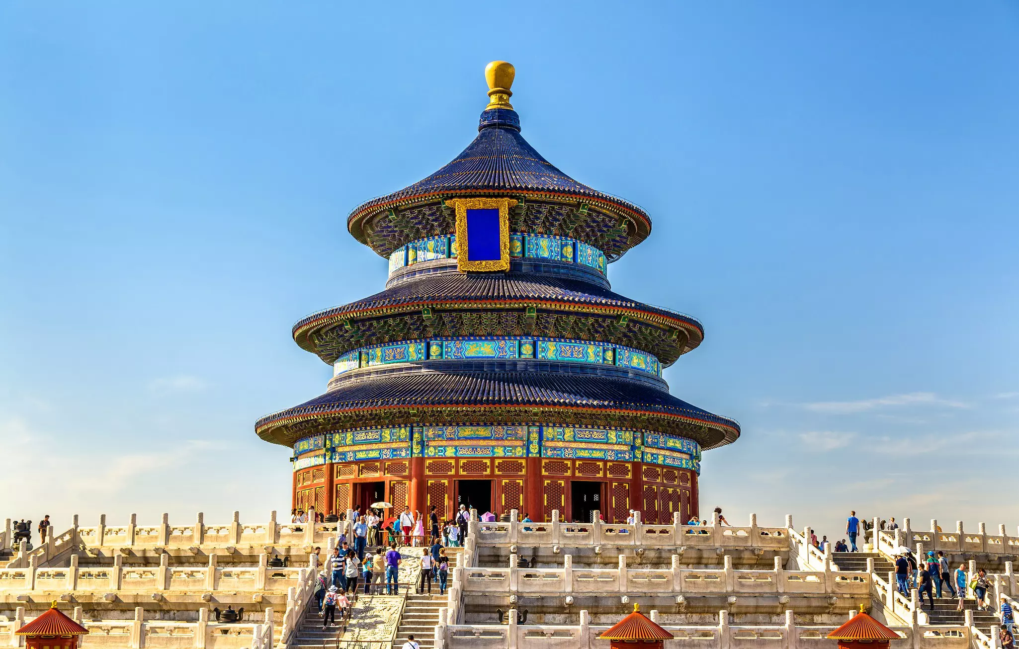 A three-tiered pagoda structure stands at the top of a flight of steps. The exterior of the structure is covered in multicolored tiles and decorations.