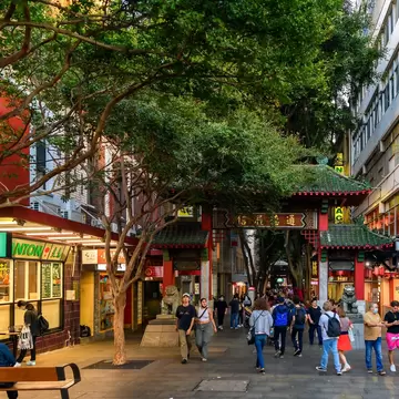 Chinatown main entrance with people walking by during evening time in Sydney, Australia.