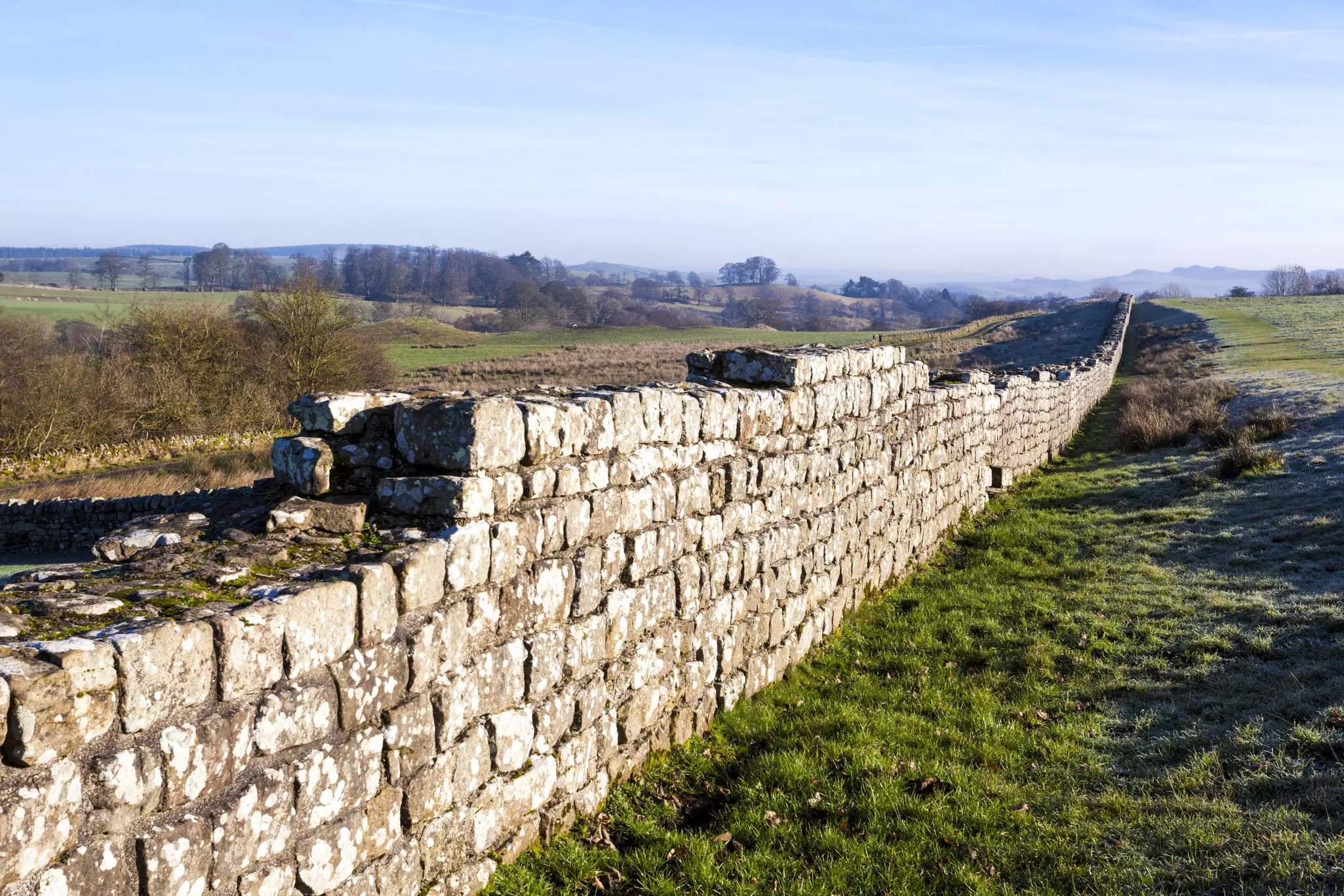 Hadrian's Wall, with some stones missing, runs to the horizon.