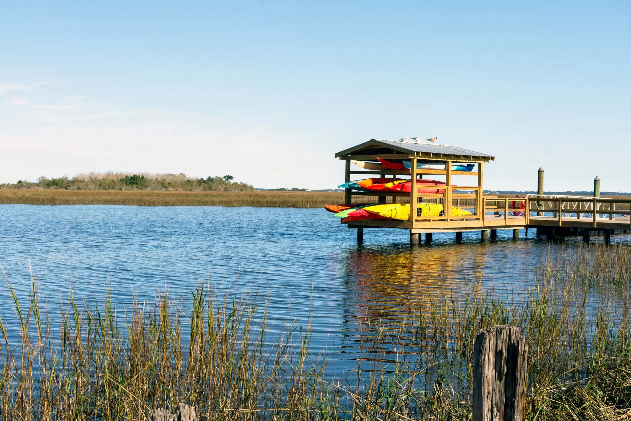 Colourful kayaks are stored on a dock overlooking the beautiful lowcountry salt marsh between Jekyll Island and St. Simons Island, Georgia, in the southeastern United States., License Type: media, Download Time: 2025-03-16T18:13:06.000Z, User: carolfarrell170, Editorial: false, purchase_order: 56530 - Guidebooks, job: Global Publishing WIP, client: Georgia & the Carolinas 4, other: Carol Farrell