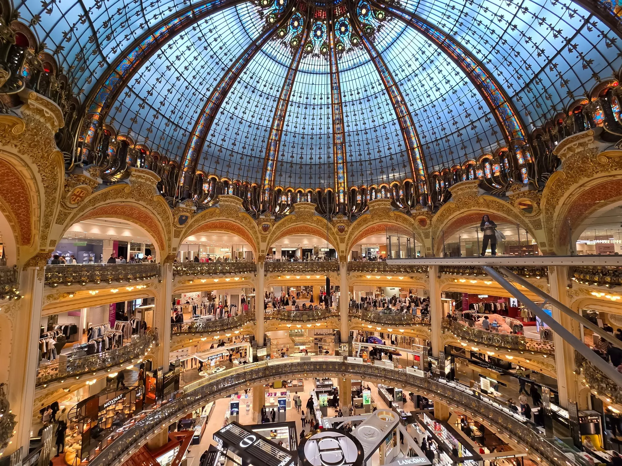 Balconies in a department store with a vast stained-glass dome above.