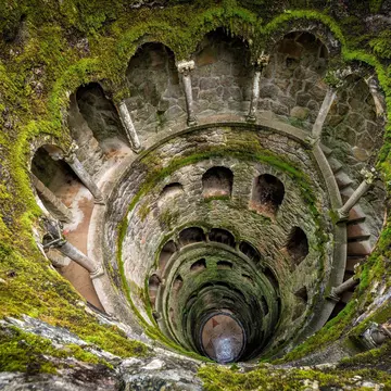 An inverted tower built into the ground resembling a well but with a stepped walkway surrounding the edge