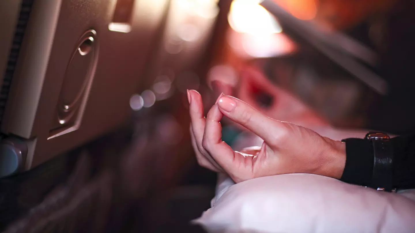 The hand of a person in an airplane doing yoga to relax