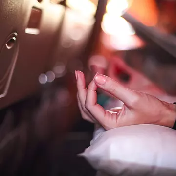 The hand of a person in an airplane doing yoga to relax