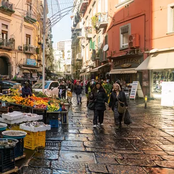 A seafood stand at a street market on a cobbled street in a city.