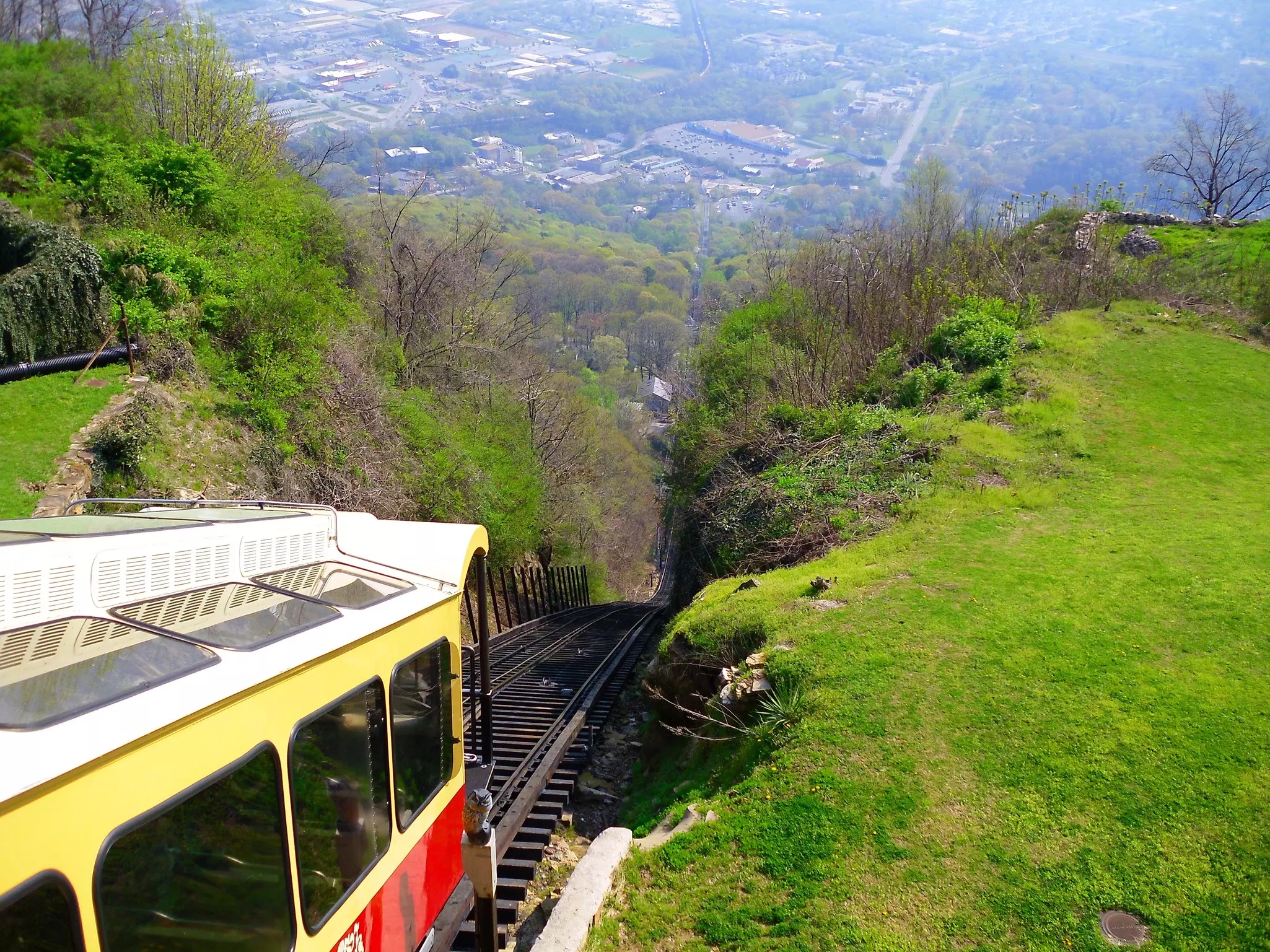 A red and yellow funicular train carriage on a very steep descent