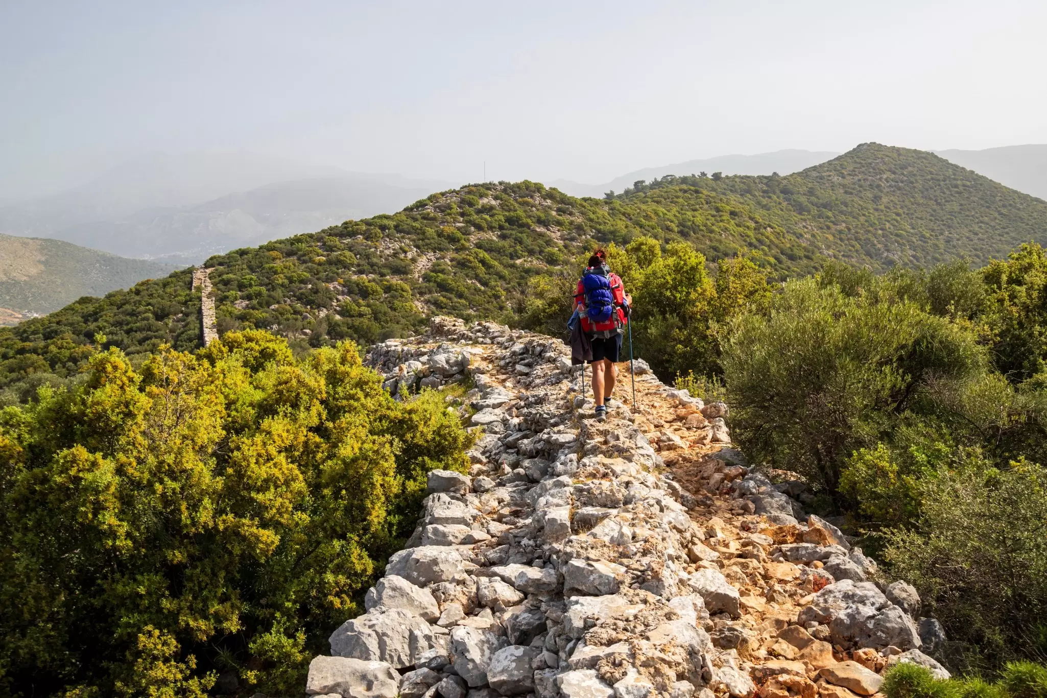 A hiker walks on a stone path.