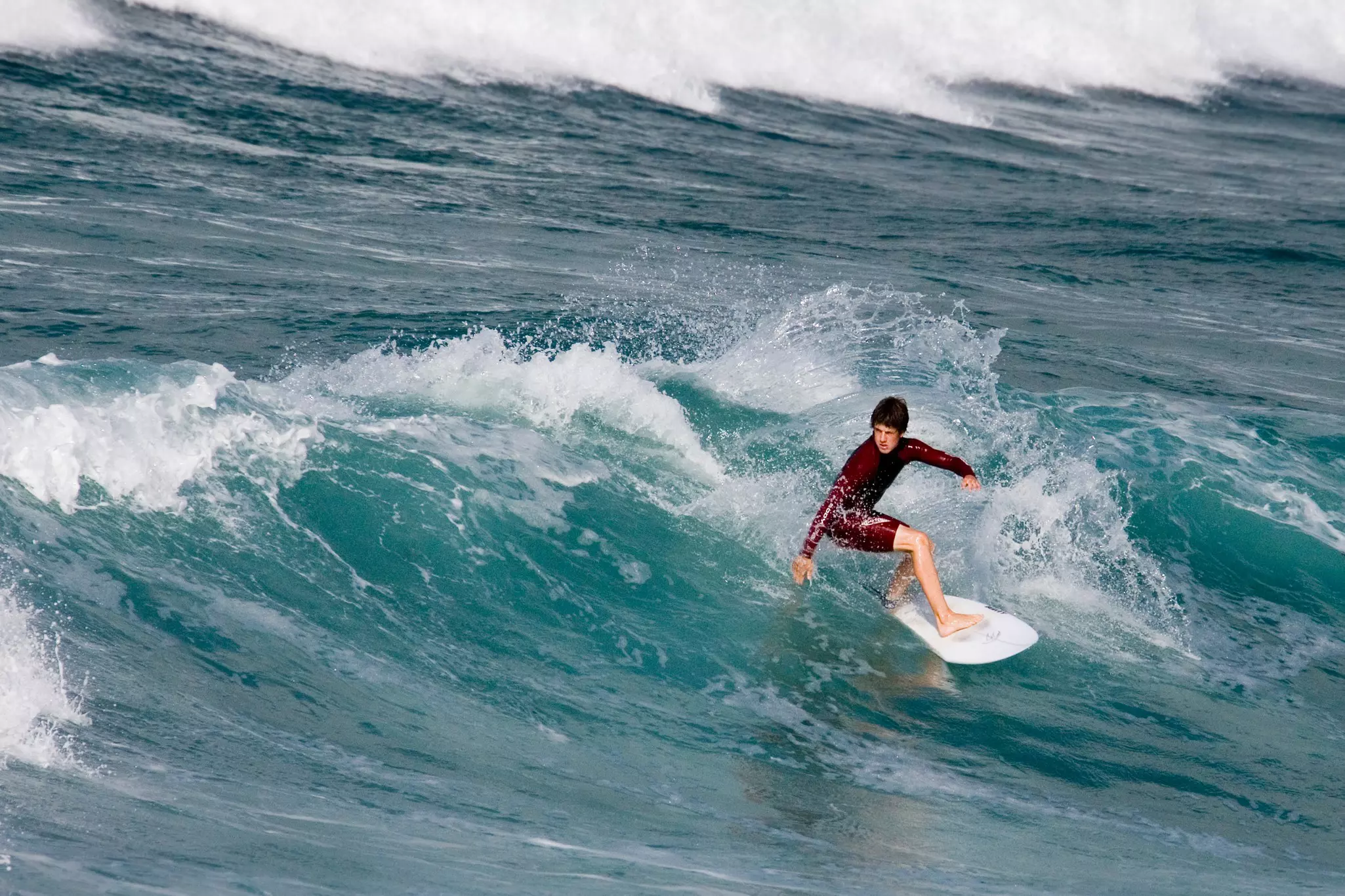 A surfer riding a wave off Fistral Beach in Newquay in Cornwall, England.