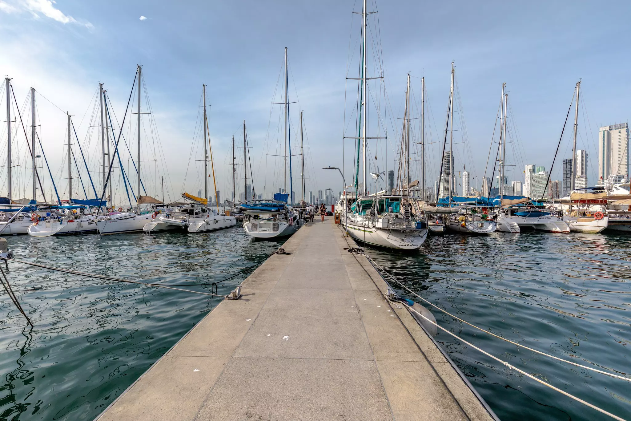 A pier leading to sailboats docked in the water in Colombia.