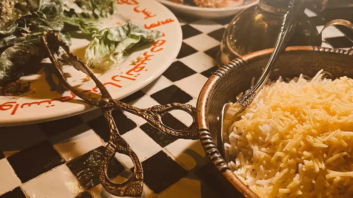 Close-up of plates of food on a table with serving implements.