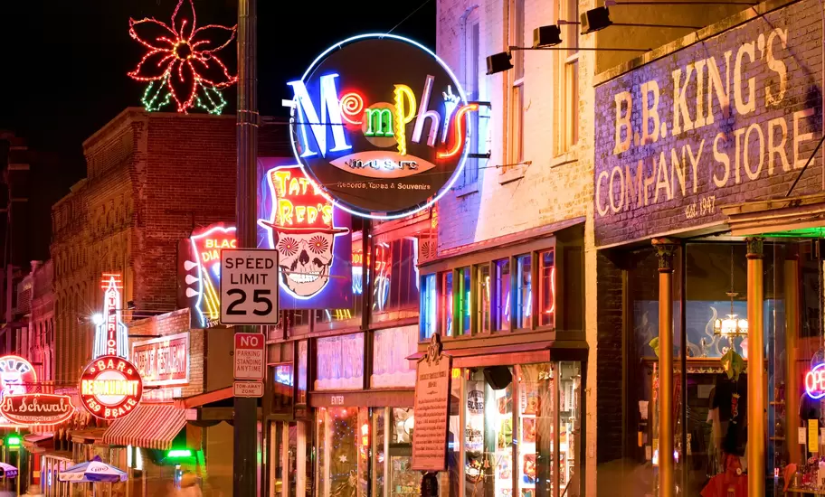 Beale Street, Memphis, at night with neon signs for Memphis Music, Tater Red's and B.B. King's Company Store