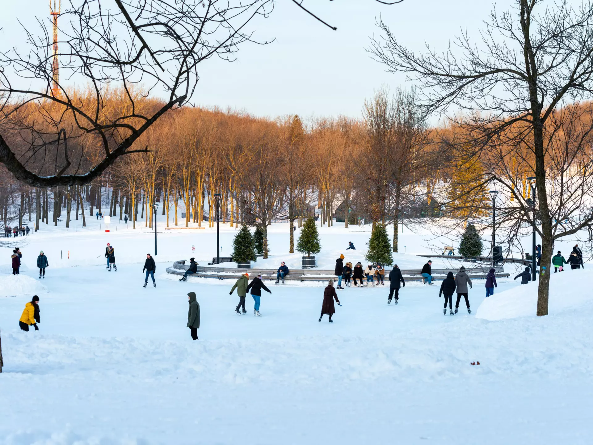 Montreal Quebec Canada January 22 2020: Skaters at Pavillon du Lac aux Castors on mount Royal park with trees in background, License Type: media, Download Time: 2025-12-09T18:04:51.000Z, User: lonelyplanetmedia, Editorial: true, purchase_order: 65020 - Marketing or Sales - this includes sponsored articles, job: Montreal , client: Montreal , other: Pia Peterson Haggarty