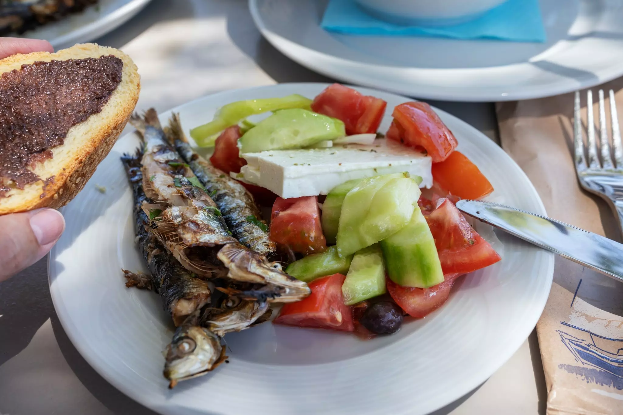 Grilled fish sardines. Freshly fish  with Greece salad in white plate. 