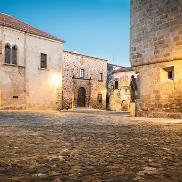 View of stone buildings in the Plaza de Santa María in Cáceres, Spain.